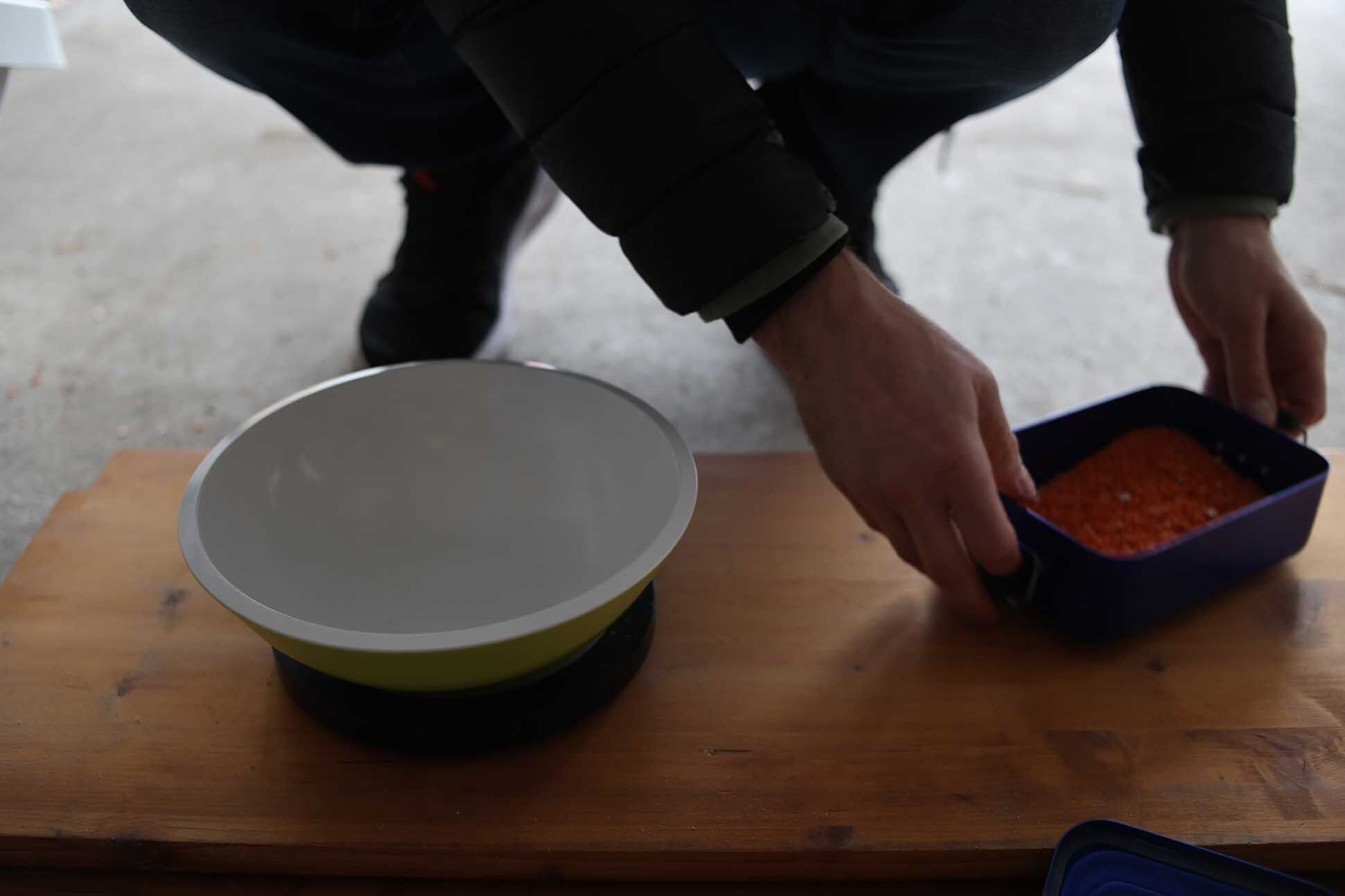 Взвешивание содержимого мобильного пылесборника Roborock S8 Pro Ultra после испытания на мощность всасывания.